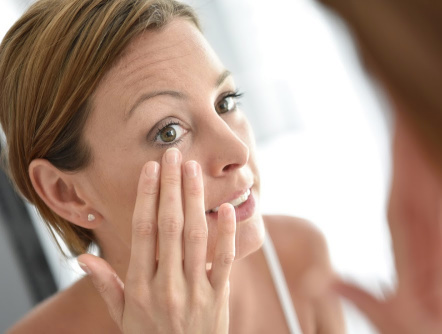 Woman looking at face in mirror