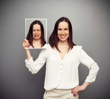 Happy woman holding sad woman picture