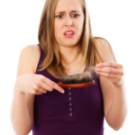 Woman seeing hair loss on brush