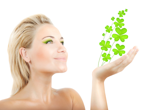 woman holding four leaf clovers